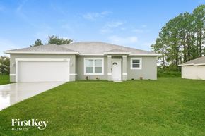 Poinciana house for rent - the exterior of a home with a green lawn and a white house