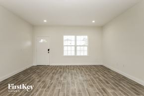 Poinciana house for rent - the spacious living room with wood flooring and a white door