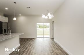 Poinciana house for rent - an empty kitchen and living room with white walls and wood flooring