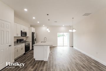 Poinciana house for rent - an open kitchen and living room with a marble counter top