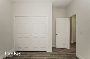 Poinciana house for rent - a bedroom with two closets and a door to a hallway