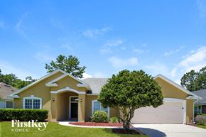 Fleming Island house for rent - a beige house with a tree in front of it