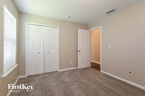 Fleming Island house for rent - a bedroom with two closets and a carpeted floor and two doors