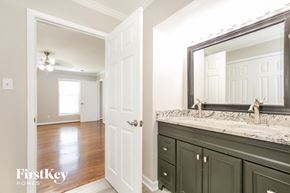 Winston-Salem house for rent - a bathroom with a sink and a mirror and a hall to a bedroom