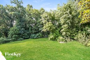 Winston-Salem house for rent - a backyard with a green lawn and trees