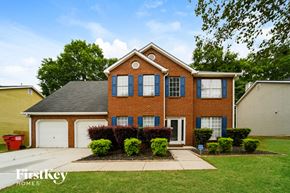 Jonesboro house for rent - the front of a brick house with a lawn and a driveway