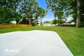Jonesboro house for rent - a large concrete area in a yard with trees and a fence