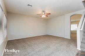 San Tan Valley house for rent - A spacious room with a ceiling fan and carpeted floor.