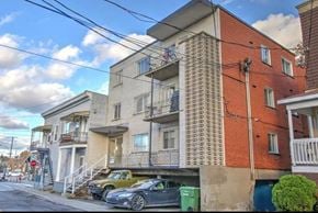 Montréal apartment for rent - the apartment building has two cars parked underneath it