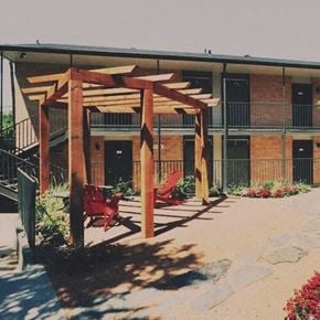 Fort Worth apartment for rent - a building with a patio with red chairs