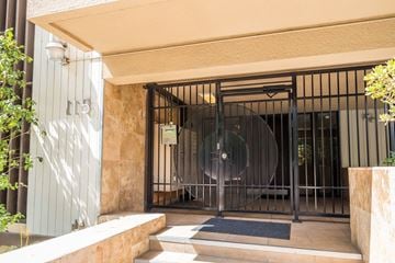 Oakland apartment for rent - A building entrance with a gate and a round glass door.