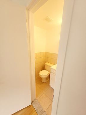 Saint-Laurent apartment for rent - A small bathroom with a toilet and a tiled wall.