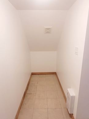 Saint-Laurent apartment for rent - A white wall with a light switch and a white radiator on the floor.