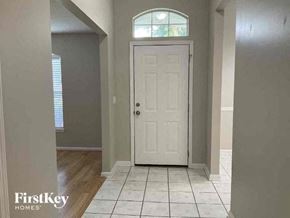 St Johns house for rent - a hallway with a white door and a tiled floor