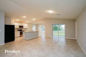Cape Coral house for rent - an empty kitchen and living room with a door to the backyard