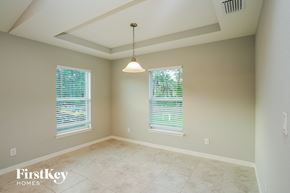 Cape Coral house for rent - an empty dining room with two windows and a ceiling light