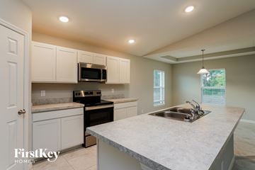 Cape Coral house for rent - a kitchen with white cabinets and a sink