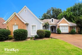 Memphis house for rent - a white and brick house with a lawn and a driveway