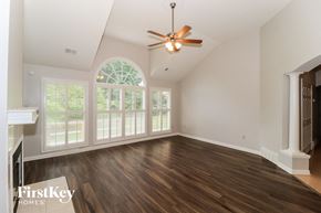 Memphis house for rent - an empty living room with a ceiling fan and large windows