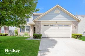 Indianapolis house for rent - a white house with a white garage door and a lawn