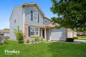 Indianapolis house for rent - a blue house with white siding and a green lawn