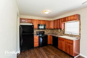 Indianapolis house for rent - a kitchen with black appliances and wooden cabinets