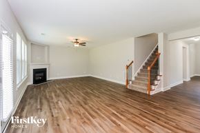 Powder Springs house for rent - a living room with wood flooring and a fireplace and a staircase