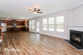 Powder Springs house for rent - an empty living room with a fireplace and a kitchen
