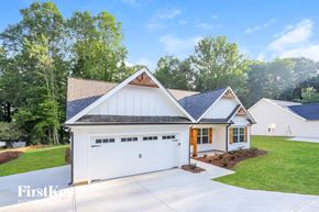 Gainesville house for rent - A white house with a brown roof and a garage door.