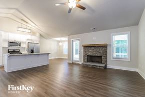 Gainesville house for rent - A spacious living room with a fireplace and a television.