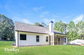 Gainesville house for rent - A house with a white exterior and a chimney is shown with the words "FirstKey Homes" on the bottom left.