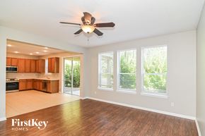 Fernandina Beach house for rent - an empty living room with a ceiling fan and a kitchen