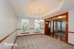 O Fallon house for rent - an empty dining room with a rug and a chandelier