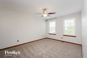 O Fallon house for rent - a bedroom with carpet and a ceiling fan and two windows