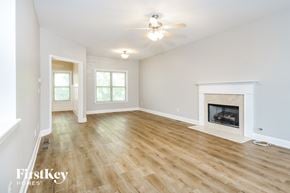 Adairsville house for rent - a living room with a fireplace and wooden floors and a ceiling fan