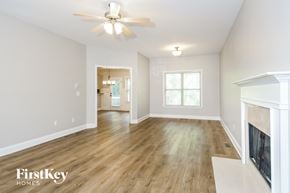 Adairsville house for rent - a living room with a fireplace and a ceiling fan