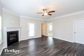 Canton house for rent - A spacious room with a fireplace and a ceiling fan.