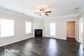 Canton house for rent - A spacious room with a fireplace and a ceiling fan.