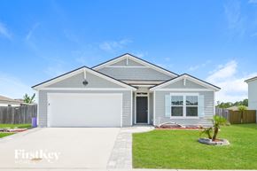 St Augustine house for rent - a blue house with a lawn and a white garage door