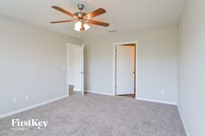 St Augustine house for rent - a bedroom with white carpet and a ceiling fan