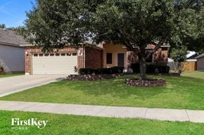 Cibolo house for rent - A tree in a grassy area with a house in the background.