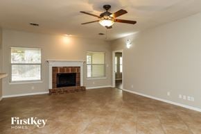 Cibolo house for rent - A spacious living room with a fireplace and a ceiling fan.
