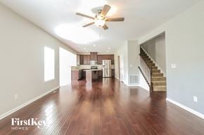 Greenwood house for rent - an open living room and kitchen with wood flooring and a ceiling fan