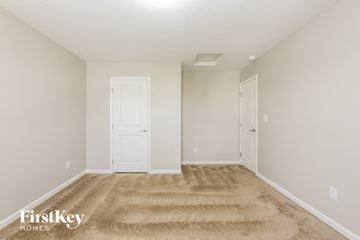 Greenwood house for rent - a spacious living room with carpet and white doors