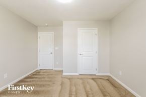 Greenwood house for rent - a bedroom with two doors and a carpeted floor