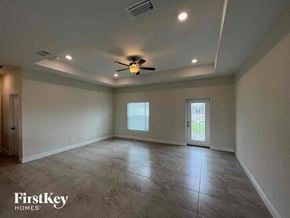 Cape Coral house for rent - an empty living room with a ceiling fan