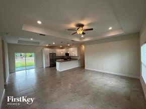 Cape Coral house for rent - an empty living room and kitchen with a ceiling fan