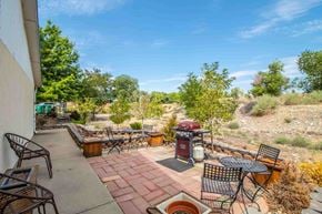 Farmington apartment for rent - a patio with tables and chairs and a grill in a backyard