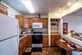 Farmington apartment for rent - a kitchen with wooden cabinets and appliances and a dining table