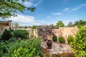 Farmington apartment for rent - a garden with a vase and plants in front of a wall